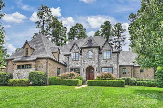 3032 Kings Manor Dr, Matthews, NC 28104 - french country style house with a front lawn, stone siding, and brick siding
