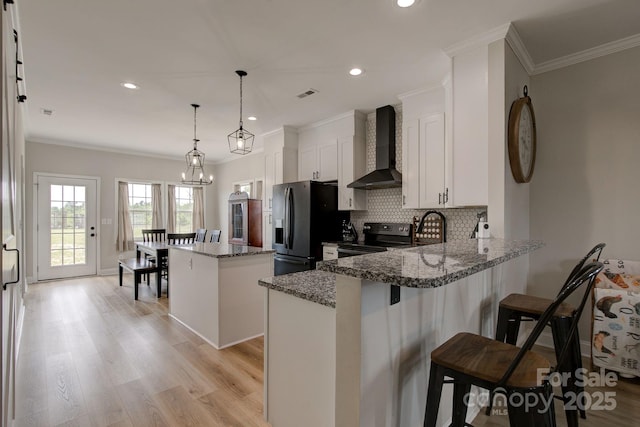 1202 Neds Creek Rd, Kershaw, SC 29067 - kitchen featuring wall chimney range hood, electric range, a kitchen island, decorative backsplash, and a peninsula