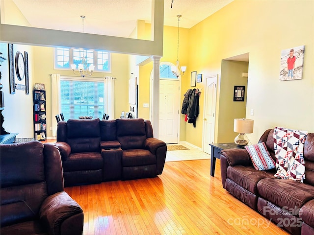 104 Laura Ct, Cherryville, NC 28021 - living area with a chandelier, light wood finished floors, a towering ceiling, and decorative columns