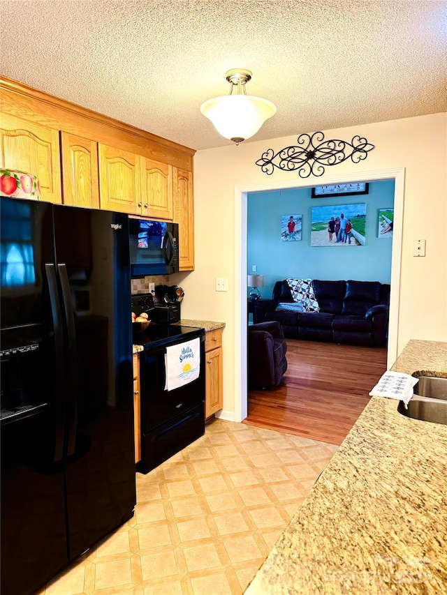 104 Laura Ct, Cherryville, NC 28021 - kitchen featuring black appliances, a textured ceiling, open floor plan, and light floors