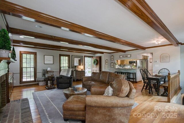 325 Chapman St, Chesterfield, SC 29709 - living room featuring beamed ceiling, light wood-style floors, a brick fireplace, and baseboards