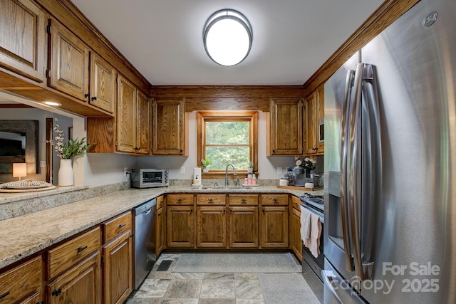 325 Chapman St, Chesterfield, SC 29709 - kitchen with appliances with stainless steel finishes, a sink, brown cabinetry, and light stone counters