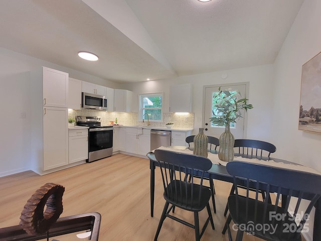 2070 Stirewalt Rd, China Grove, NC 28023 - kitchen featuring stainless steel appliances, backsplash, light countertops, white cabinetry, and lofted ceiling