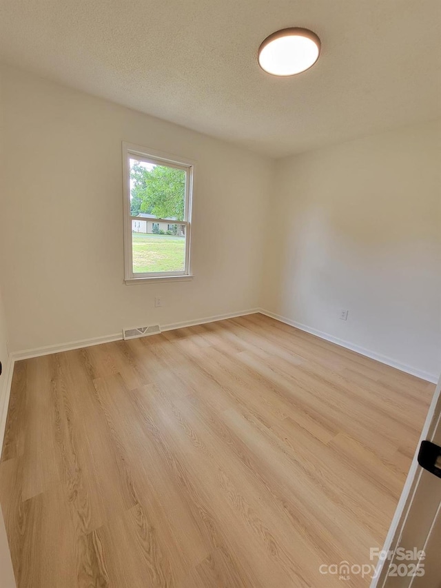 2070 Stirewalt Rd, China Grove, NC 28023 - empty room with light wood-style flooring, baseboards, and a textured ceiling