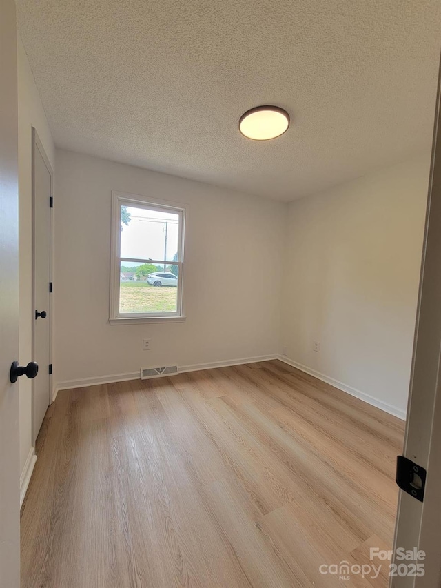 2070 Stirewalt Rd, China Grove, NC 28023 - spare room featuring wood finished floors, a textured ceiling, and baseboards