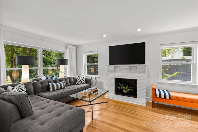2424 Cumberland Ave, Charlotte, NC 28203 - living area with wood finished floors, a fireplace, recessed lighting, and ornamental molding
