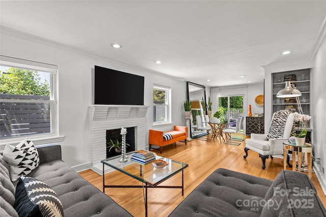 2424 Cumberland Ave, Charlotte, NC 28203 - living area featuring ornamental molding, wood finished floors, recessed lighting, and a brick fireplace