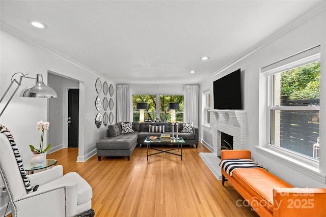 2424 Cumberland Ave, Charlotte, NC 28203 - living area with light wood-style floors, crown molding, baseboards, recessed lighting, and a brick fireplace
