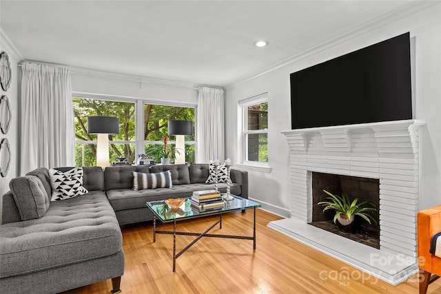 2424 Cumberland Ave, Charlotte, NC 28203 - living room featuring plenty of natural light, ornamental molding, wood finished floors, a brick fireplace, and recessed lighting