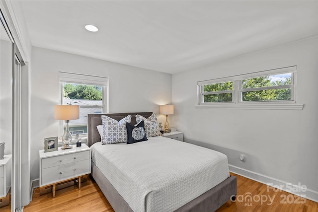2424 Cumberland Ave, Charlotte, NC 28203 - bedroom with multiple windows, light wood-style flooring, a closet, baseboards, and recessed lighting