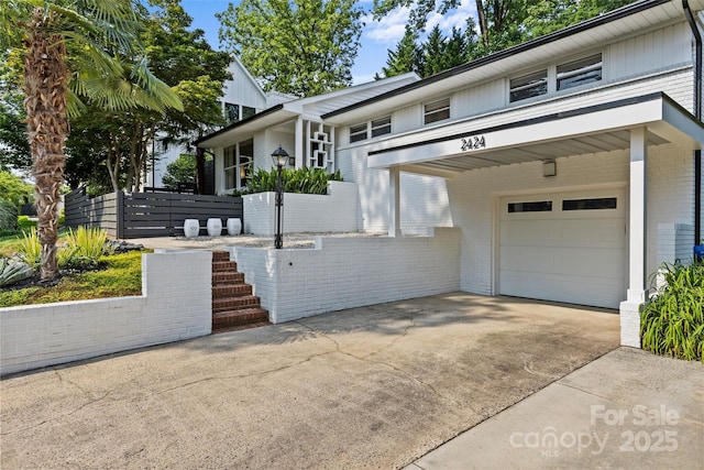 2424 Cumberland Ave, Charlotte, NC 28203 - view of front of home with brick siding, a garage, and concrete driveway