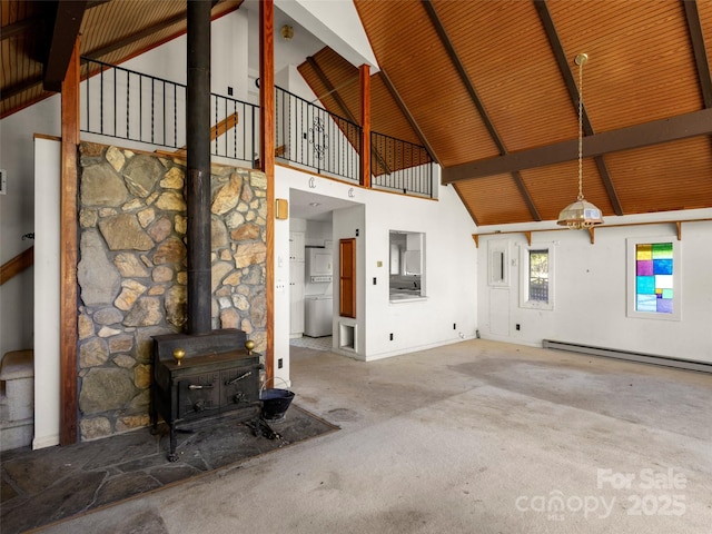 272 Pinners Cove Rd, Asheville, NC 28803 - unfurnished living room with a baseboard heating unit, high vaulted ceiling, a wood stove, and beam ceiling