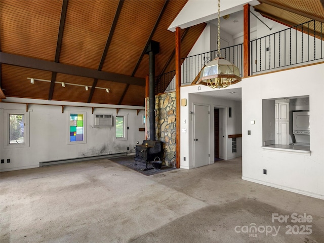 272 Pinners Cove Rd, Asheville, NC 28803 - unfurnished living room featuring a baseboard heating unit, high vaulted ceiling, a wood stove, an AC wall unit, and carpet floors