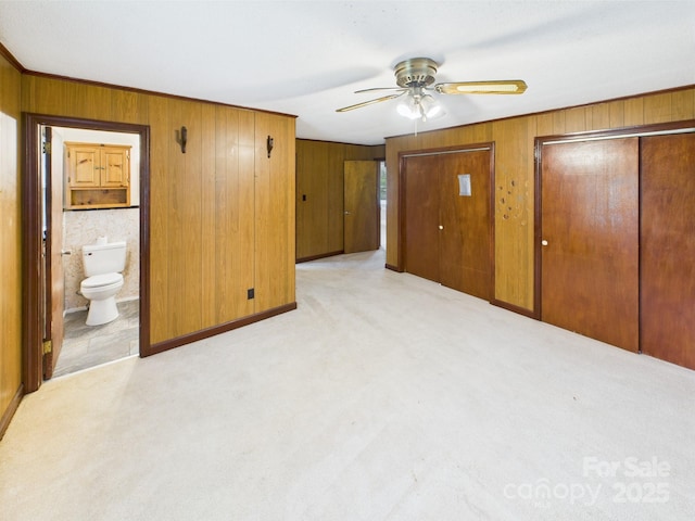 271 NC-16 Hwy N, Taylorsville, NC 28681 - unfurnished bedroom with wooden walls, multiple closets, ensuite bathroom, light carpet, and ceiling fan