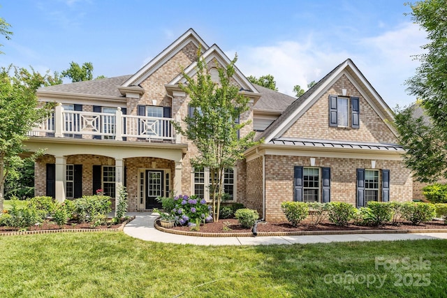 10508 Kristens Mare Dr, Charlotte, NC 28277 - view of front facade with a balcony, brick siding, a front yard, roof with shingles, and a standing seam roof