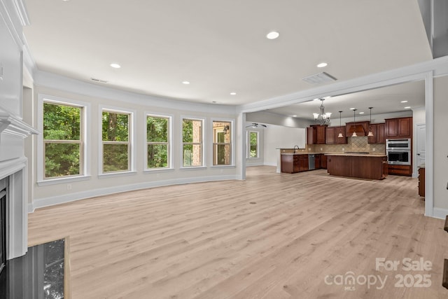 10508 Kristens Mare Dr, Charlotte, NC 28277 - unfurnished living room featuring a premium fireplace, a chandelier, baseboards, light wood finished floors, and recessed lighting