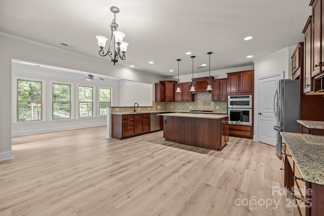10508 Kristens Mare Dr, Charlotte, NC 28277 - kitchen featuring appliances with stainless steel finishes, crown molding, tasteful backsplash, a center island, and a chandelier