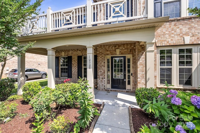 10508 Kristens Mare Dr, Charlotte, NC 28277 - doorway to property featuring a balcony, covered porch, and brick siding