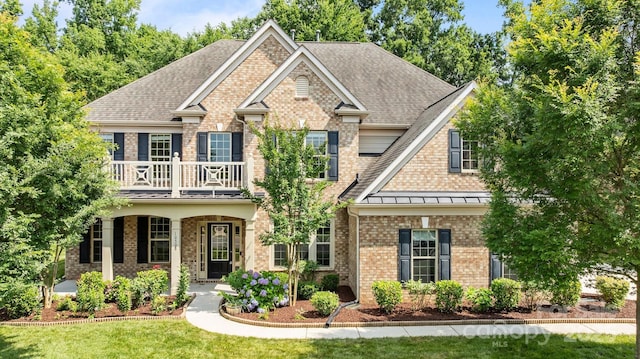 10508 Kristens Mare Dr, Charlotte, NC 28277 - view of front of home with a balcony, brick siding, roof with shingles, a front lawn, and a standing seam roof