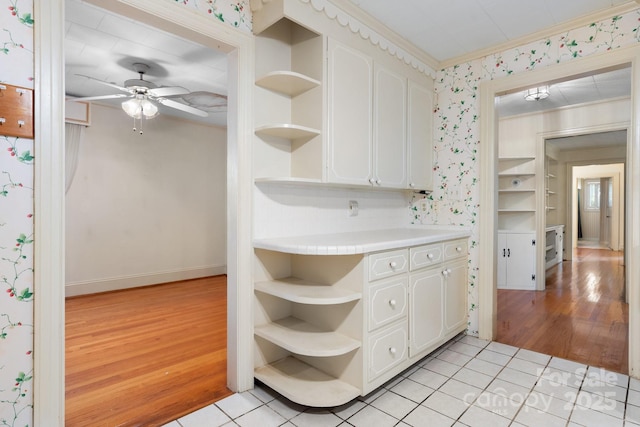4002 Hickory Blvd, Granite Falls, NC 28630 - kitchen with open shelves, wallpapered walls, white cabinetry, ceiling fan, and light wood-style flooring