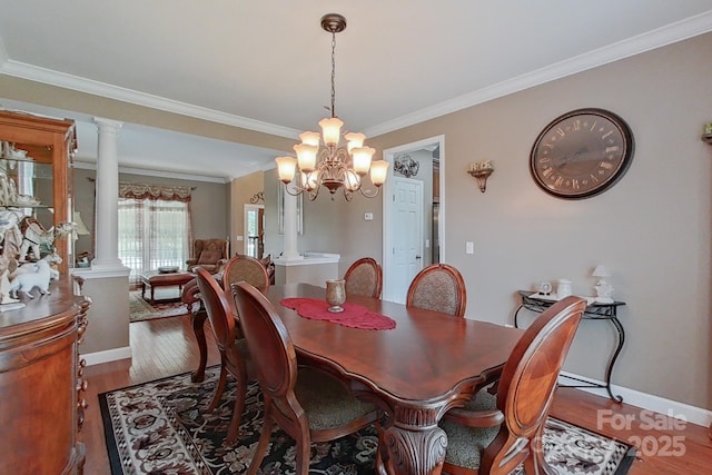 8409 Olde Stonegate Ln, Mint Hill, NC 28227 - dining room featuring ornate columns, crown molding, wood finished floors, a chandelier, and baseboards