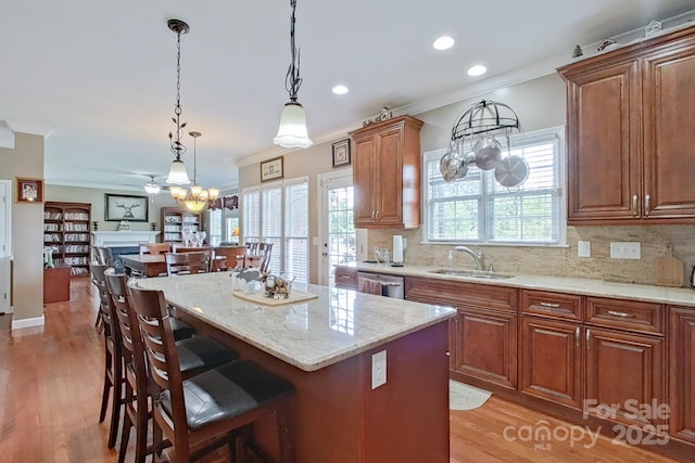 8409 Olde Stonegate Ln, Mint Hill, NC 28227 - kitchen with a sink, a breakfast bar, dishwasher, crown molding, and light stone counters