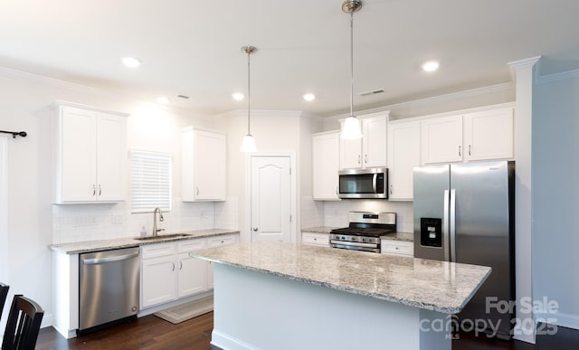 679 Cape Fear St, Fort Mill, SC 29715 - kitchen featuring appliances with stainless steel finishes, a center island, white cabinets, decorative backsplash, and crown molding