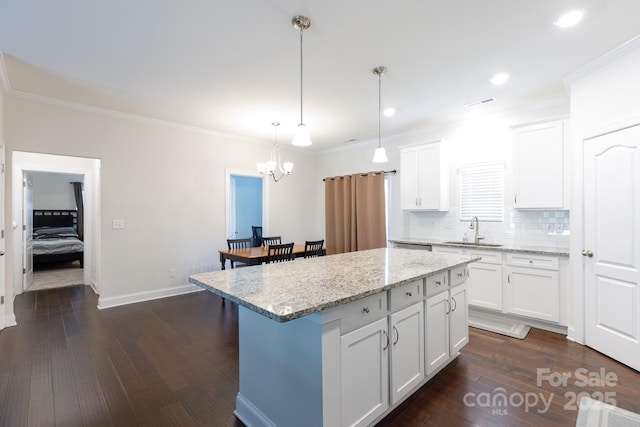 679 Cape Fear St, Fort Mill, SC 29715 - kitchen featuring a kitchen bar, a chandelier, white cabinetry, a kitchen island, and ornamental molding