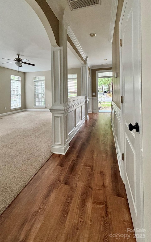 12904 Windy Lea Ln, Huntersville, NC 28078 - hallway featuring arched walkways, dark wood finished floors, a decorative wall, ornamental molding, and wainscoting