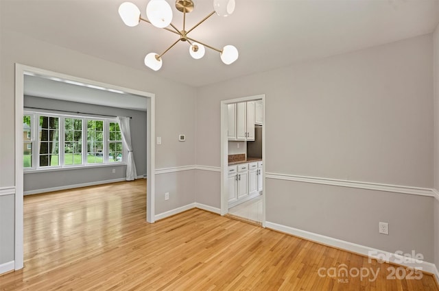 2301 Seth Thomas Rd, Charlotte, NC 28210 - spare room featuring a chandelier, light wood-style flooring, and baseboards
