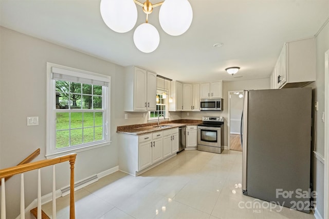 2301 Seth Thomas Rd, Charlotte, NC 28210 - kitchen with appliances with stainless steel finishes, a sink, dark countertops, white cabinetry, and baseboards