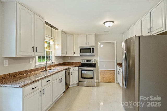 2301 Seth Thomas Rd, Charlotte, NC 28210 - kitchen with appliances with stainless steel finishes, a sink, dark stone countertops, white cabinetry, and light tile patterned flooring