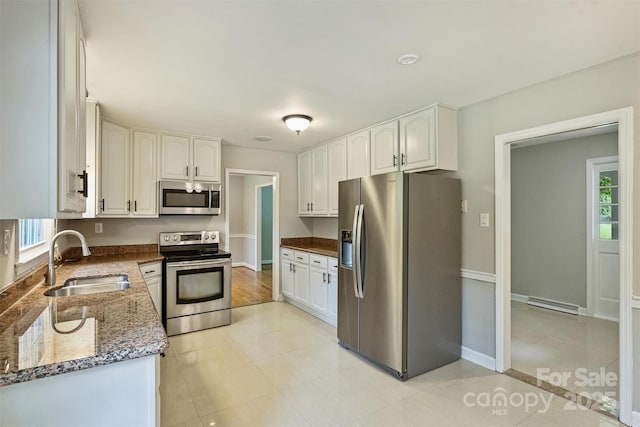 2301 Seth Thomas Rd, Charlotte, NC 28210 - kitchen with stainless steel appliances, a sink, dark stone counters, and white cabinets