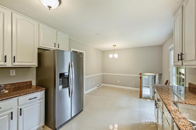 2301 Seth Thomas Rd, Charlotte, NC 28210 - kitchen featuring stainless steel fridge, dark stone counters, light tile patterned floors, and decorative light fixtures