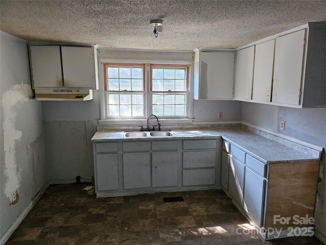 211 Putnam St, Shelby, NC 28152 - kitchen with ventilation hood, a textured ceiling, white cabinetry, and light countertops