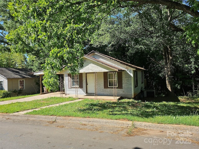 211 Putnam St, Shelby, NC 28152 - view of front facade featuring a front yard, driveway, and covered porch