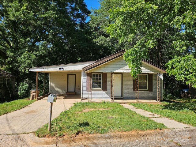 211 Putnam St, Shelby, NC 28152 - view of front facade featuring a carport, driveway, and a porch