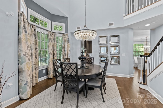 224 Wendover Heights Cir, Charlotte, NC 28211 - dining room with a chandelier, a towering ceiling, baseboards, wood finished floors, and stairway