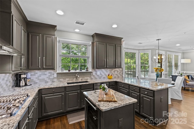 224 Wendover Heights Cir, Charlotte, NC 28211 - kitchen with stainless steel gas cooktop, a sink, wall chimney range hood, plenty of natural light, and recessed lighting