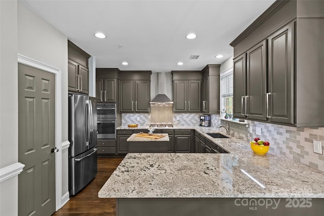 224 Wendover Heights Cir, Charlotte, NC 28211 - kitchen featuring stainless steel appliances, wall chimney exhaust hood, light stone countertops, a sink, and dark wood-type flooring