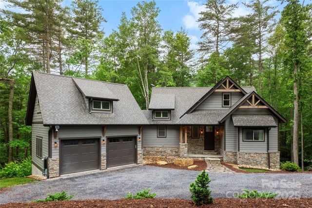 68 Huckleberry Ridge Ln, Zirconia, NC 28790 - craftsman-style home with stone siding, an attached garage, asphalt driveway, a porch, and a shingled roof