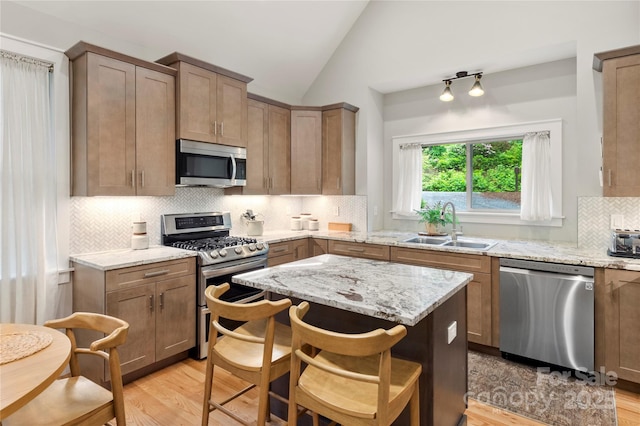 68 Huckleberry Ridge Ln, Zirconia, NC 28790 - kitchen featuring appliances with stainless steel finishes, a sink, light wood-type flooring, lofted ceiling, and a kitchen island