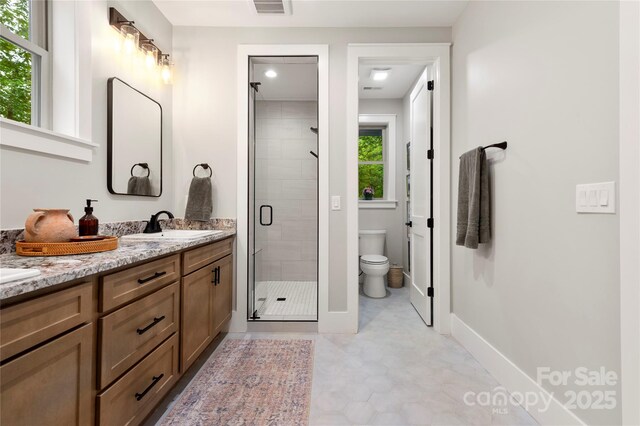 68 Huckleberry Ridge Ln, Zirconia, NC 28790 - bathroom featuring double vanity, a shower stall, toilet, and baseboards