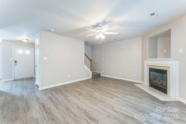 13413 Golden Apple Ct, Charlotte, NC 28215 - unfurnished living room featuring a ceiling fan, stairs, wood finished floors, a glass covered fireplace, and baseboards