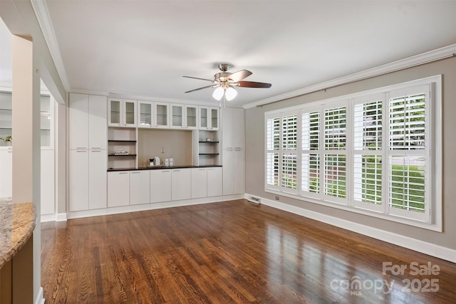 7050 Knightswood Dr, Charlotte, NC 28226 - unfurnished living room featuring ceiling fan, dark wood finished floors, ornamental molding, and healthy amount of natural light
