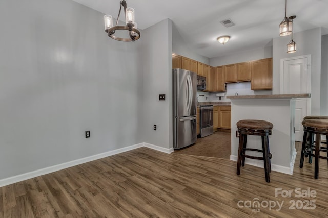 176 Brickton Village Cir Unit 302, Fletcher, NC 28732 - kitchen featuring appliances with stainless steel finishes, dark wood-style floors, baseboards, a breakfast bar area, and pendant lighting
