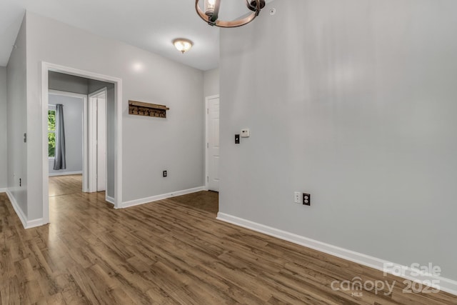 176 Brickton Village Cir Unit 302, Fletcher, NC 28732 - unfurnished room with a chandelier, wood finished floors, and baseboards