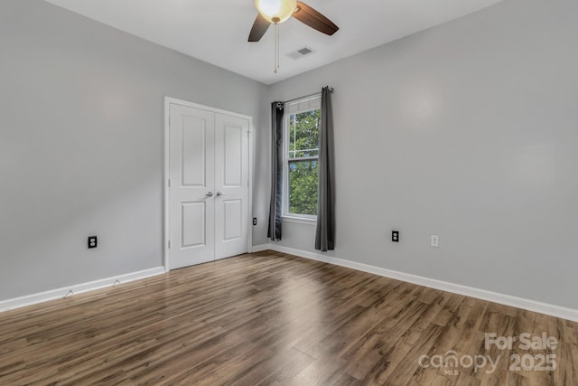 176 Brickton Village Cir Unit 302, Fletcher, NC 28732 - unfurnished bedroom with wood finished floors, baseboards, a closet, and a ceiling fan