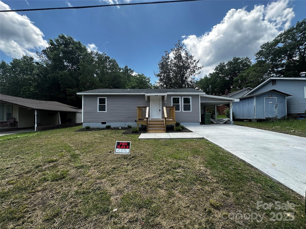 801 Calhoun St, Lancaster, SC 29720 - view of front facade featuring concrete driveway, a front lawn, an attached carport, and crawl space