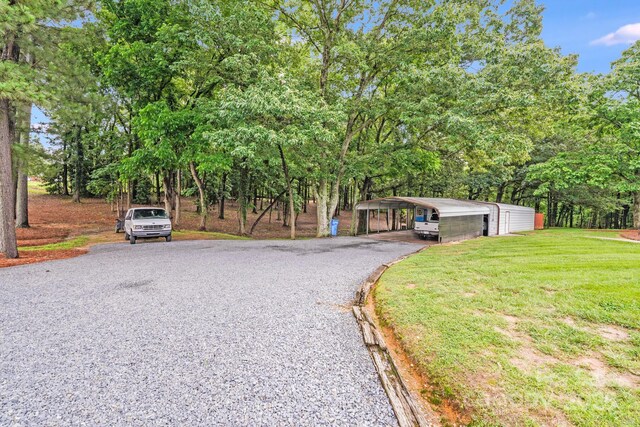 211 Drive Inn Rd, Locust, NC 28097 - view of front of property featuring driveway, a front yard, a detached carport, and view of wooded area